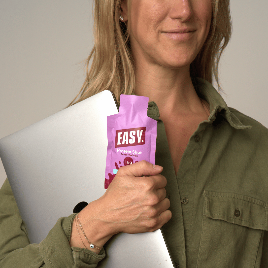 Person drinking protein shot outdoors