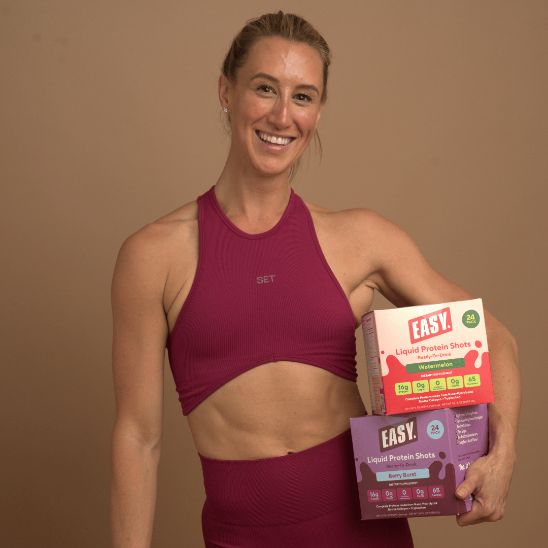 Person in workout attire holding protein shot boxes